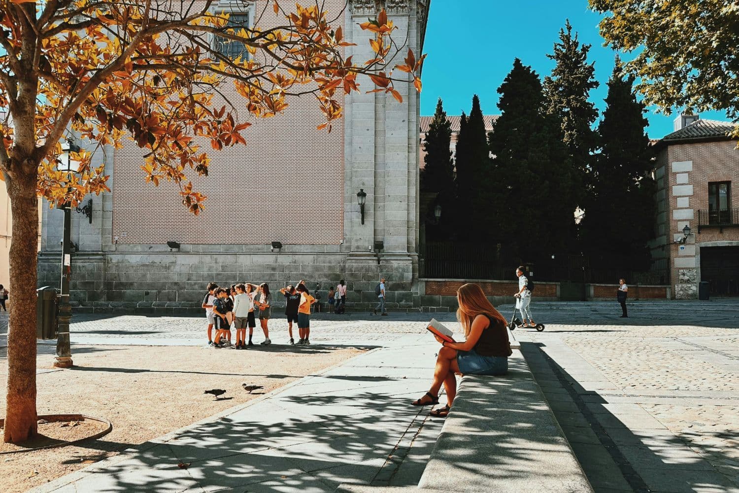 Mujer leyendo en una plaza urbana de España